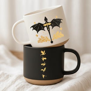 May include: A set of three ceramic mugs with a speckled, matte finish. The mugs are in shades of cream, light gray, and dark gray. Each mug has a simple, minimalist design, perfect for coffee or tea.