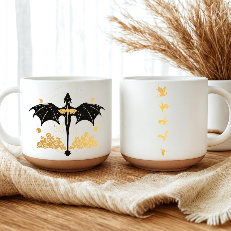 May include: Two white ceramic mugs with brown bottoms. One mug features a black dragon design with gold accents. The other mug has a series of gold dragon silhouettes. Both mugs have a curved handle.
