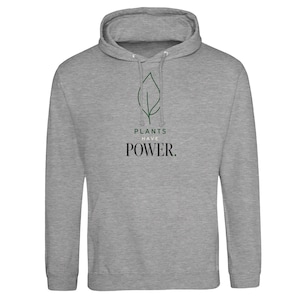Könnte beinhalten: Ein graumelierter Kapuzenpullover mit einer dunkelgrünen Strichzeichnung eines Blattes in der Mitte der Brust. Unter dem Blatt steht der Text PLANTS in Grün, HAVE in kleinen schwarzen Buchstaben und POWER. in einer großen schwarzen Serifenschrift.