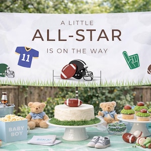 May include: A baby shower scene with a banner that reads "A Little All-Star Is On The Way." Decorations include a cake, cupcakes, teddy bears, and football-themed items. Balloons and a popcorn box add to the festive atmosphere.