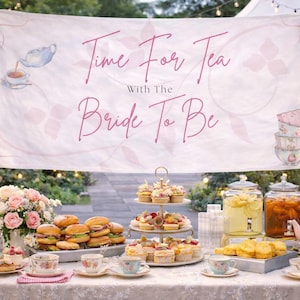 May include: A bridal tea party table with a banner reading "Time For Tea With The Bride To Be." The table is set with sandwiches, cupcakes, and tea sets. A pink teapot and a bouquet of pink roses enhance the celebratory feel of the event.