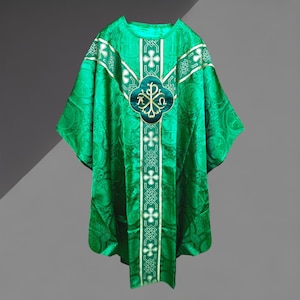 Può includere: Veste liturgica verde smeraldo con intricati motivi a croce e floreali. La veste presenta un emblema centrale con accenti dorati e un design ripetuto. Il tessuto ha una sottile lucentezza e il design include finiture bianche e dorate.