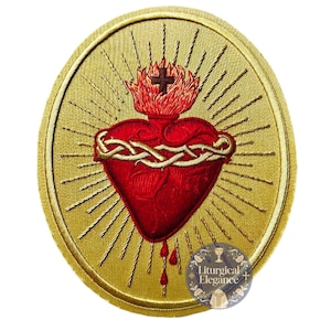 May include: Embroidered patch featuring a red Sacred Heart design with a crown of thorns, flames, and a cross. The heart is surrounded by gold rays on a gold background. The patch has a circular shape and a gold border.