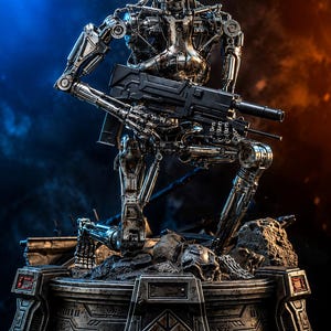 May include: A metallic silver robotic skeleton figure in a kneeling position, holding a black rifle. The figure features exposed mechanical joints, wires, and glowing red eyes. It is mounted on a circular, weathered base with debris and skulls.