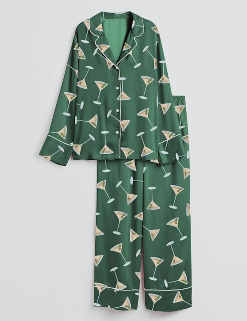 K&ouml;nnte beinhalten: Gr&uuml;nes Pyjama-Set mit Martini-Glas-Muster. Das lang&auml;rmlige Oberteil hat eine Knopfleiste und wei&szlig;e Paspeln. Die passende Hose ist gerade geschnitten. Der Pyjama ist aus seidigem Material.