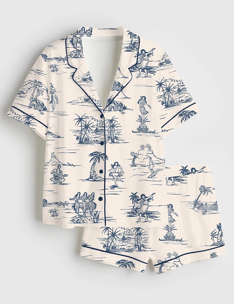 May include: Cream-colored pajama set featuring a navy blue tropical print. The set includes a short-sleeved button-down shirt and matching shorts. The print depicts island scenes with palm trees, dancers, and musicians.