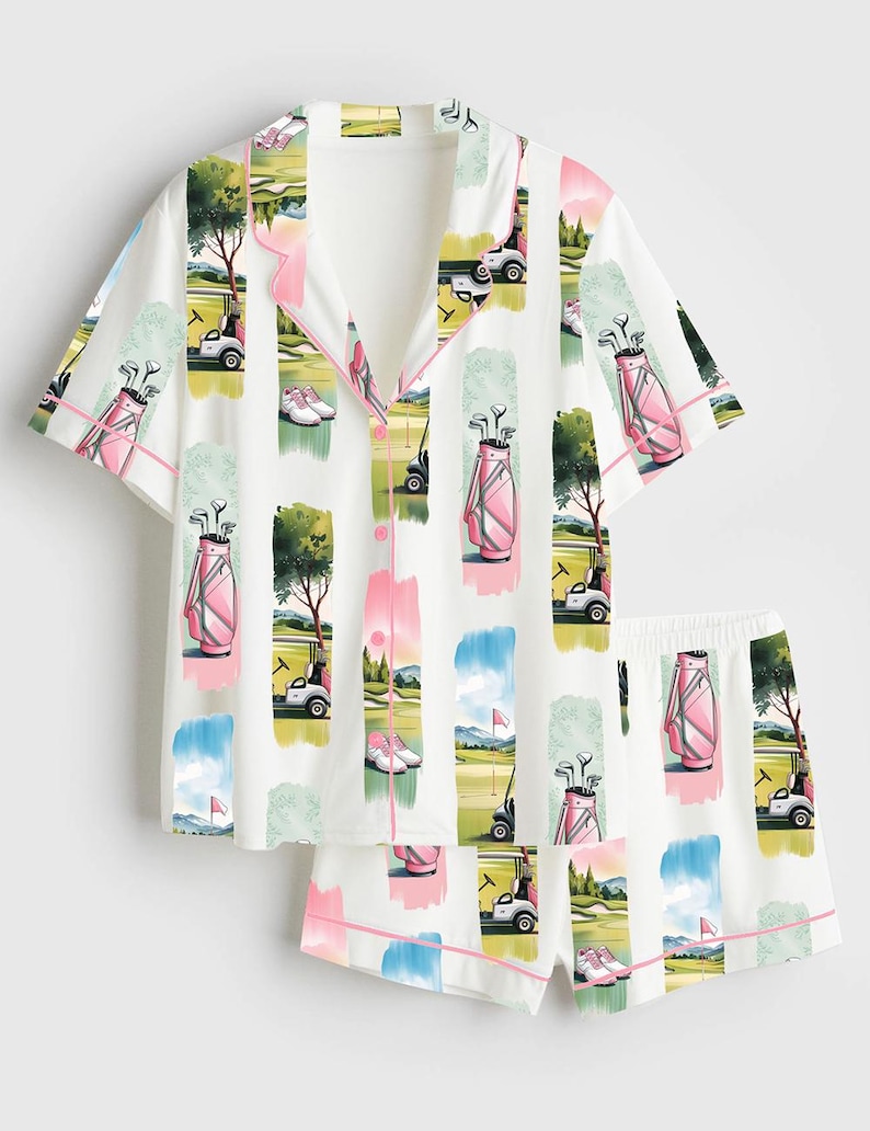 Peut inclure: Ensemble de pyjama blanc sur le th&egrave;me du golf. Le haut &agrave; manches courtes et le short pr&eacute;sentent un motif r&eacute;p&eacute;t&eacute; de sacs de golf, de voiturettes et de sc&egrave;nes de parcours en rose, vert et bleu. Bordure rose.