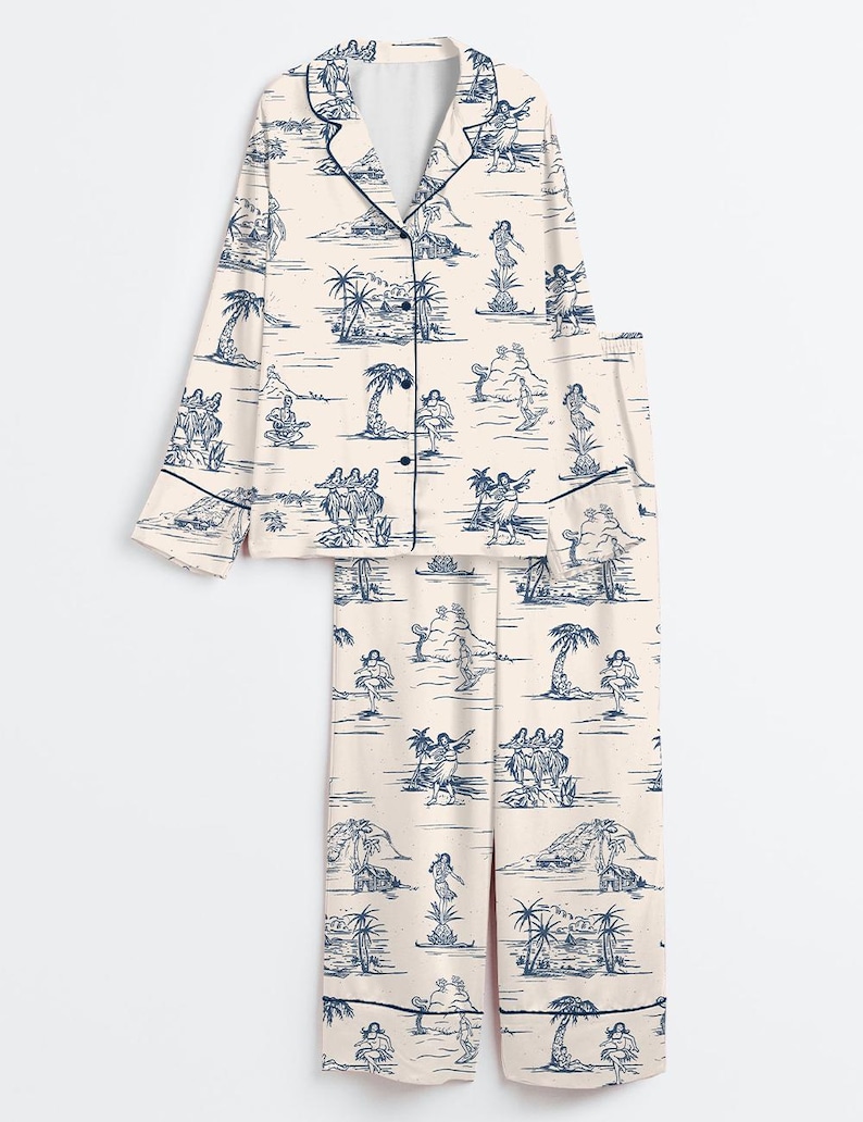 May include: A two-piece pajama set in a cream color with a blue island-themed print. The long-sleeved top has a button-down front and navy trim. The matching pants have a relaxed fit. The print features palm trees, dancers, and musicians.