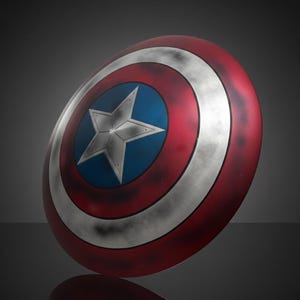 May include: A round shield with a red, white, and blue color scheme. The shield features a white star on a blue center, surrounded by concentric red and white bands. The shield is slightly angled, with a reflection visible below.