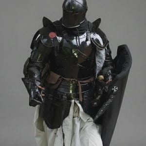 Puede incluir: Una armadura negra brillante completa, que incluye un casco, una placa para el pecho y protectores para las piernas. La armadura tiene un acabado pulido, que refleja la luz. Un escudo negro se sostiene en el lado derecho. El texto "Glossy Black Color" est&aacute; en la parte superior.