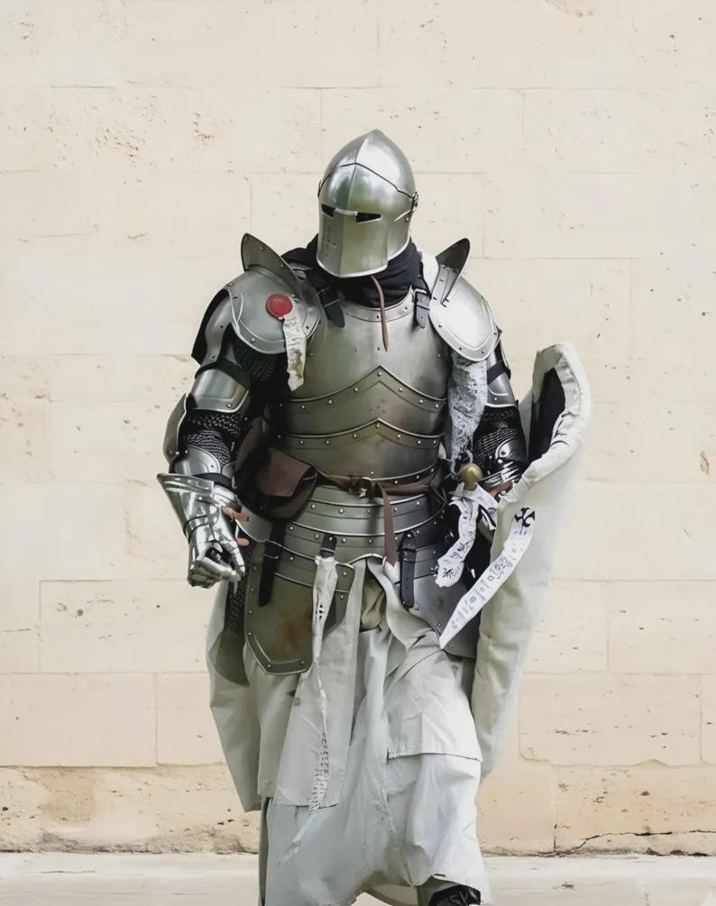 Puede incluir: Una armadura medieval completa, que incluye un casco, una coraza y guanteletes. La armadura es de color plateado y se usa sobre una t&uacute;nica blanca. Tambi&eacute;n se ven un escudo y una espada.