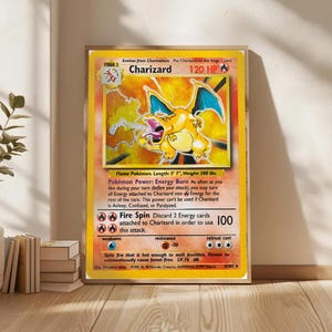 May include: Framed Charizard Pokémon card. The card features a yellow background with a Charizard illustration. The card text includes "Charizard", "120 HP", and "Fire Spin". The card is 5' 7" long and weighs 200 lbs.