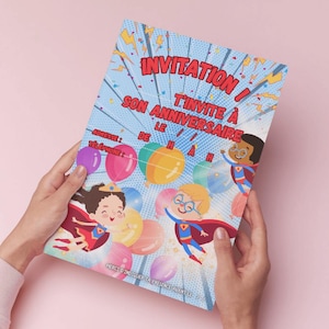 May include: A colorful invitation card with the text "INVITATION! SON ANNIVERSAIRE T'INVITE À" and illustrations of superheroes and balloons. The card has space for address and phone number.