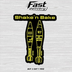 May include: A black sticker with yellow text and graphics. The text reads "Shake'n Bake" above two yellow stylized bomb illustrations. The text "Fast delivery" is at the top. The bottom text reads "BUY 3 GET 1 FREE".