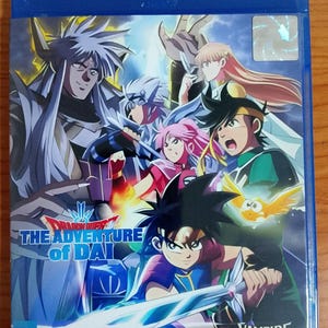 Puede incluir: Una caja azul de Blu-ray con ilustraciones de anime coloridas. La portada presenta varios personajes con espadas y elementos mágicos. El título "Dragon Quest The Adventure of Dai" es visible.