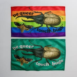 May include: Two rectangular flags, one rainbow-coloured and the other green, each with a large beetle and moth illustration. The text "be queer touch bugs" is printed on each flag.