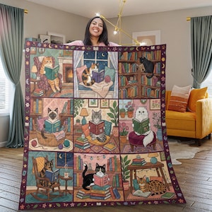 May include: A large, rectangular throw blanket featuring a whimsical design of cats reading books in various cozy settings. The blanket has a dark purple border with stars and moons. The central design is a grid of illustrated scenes.