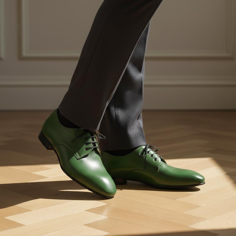 May include: Green leather dress shoes with black laces. The shoes are a vibrant green color and have a classic, formal design. The image shows the shoes from a low angle, highlighting their polished appearance.