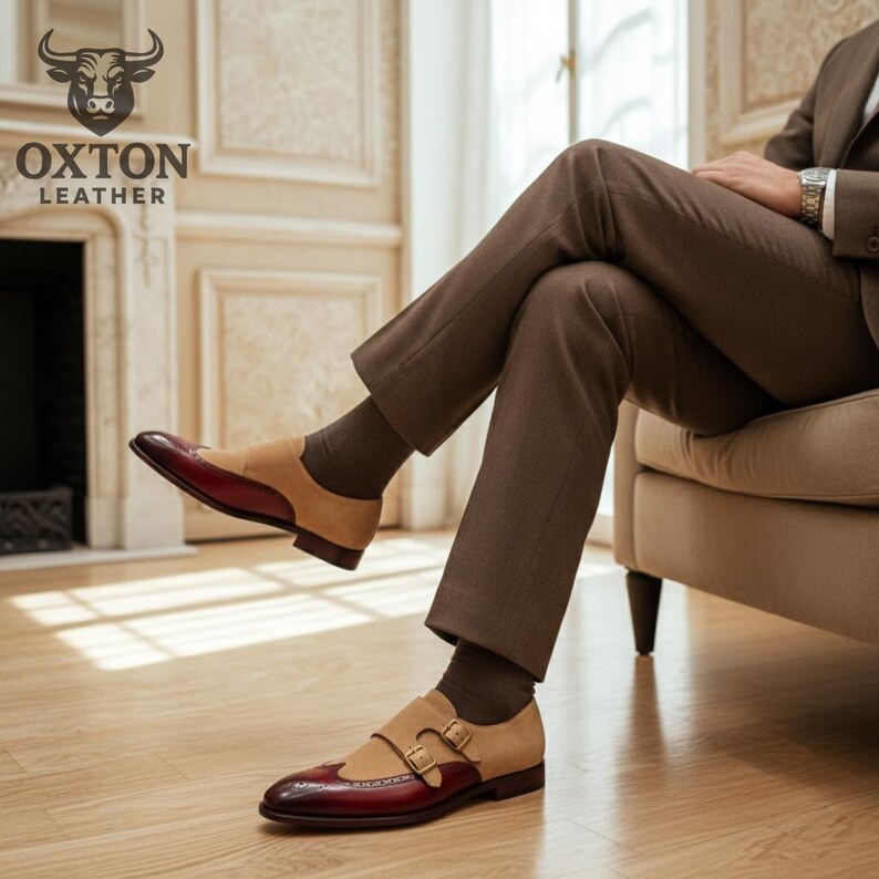May include: Two-tone leather dress shoes with a double monk strap buckle closure. The shoes feature a burgundy toe and heel, tan suede midsection, and a brown sole. The Oxton Leather logo is visible in the upper left corner.