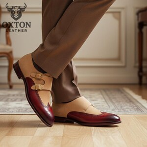 May include: Two-tone leather dress shoes with a double monk strap fastening. The shoes have a burgundy toe and heel, with a tan suede upper. The image also shows the "OXTON LEATHER" logo.