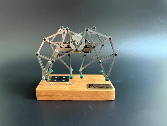 A motorized Theo Jansen-inspired mechanical walker in metal — legs that move like a living creature, straight out of an engineering fever dream.