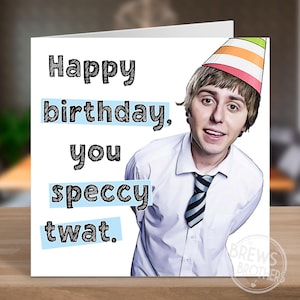 May include: A birthday card with the text "Happy birthday, you speccy twat." The card features a man wearing a party hat and a white shirt with a striped tie. The card is on a wooden surface.