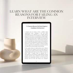 May include: A digital tablet displays text about interview failures, with the title "Common Reasons Full Stack Engineer Candidates Fail Interviews." A beige, abstract ceramic vase is on the left.