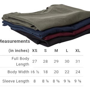 May include: A stack of five folded t-shirts in various colors: olive green, navy blue, burgundy, and black. The image includes a size chart with measurements in inches for full body length, body width, and sleeve length.