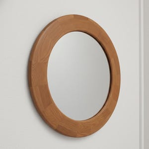 Peut inclure: Un miroir rond avec un cadre en bois brun clair. Le cadre est composé de morceaux de bois rectangulaires. Le miroir est fixé sur un mur blanc. La forme du miroir est circulaire.