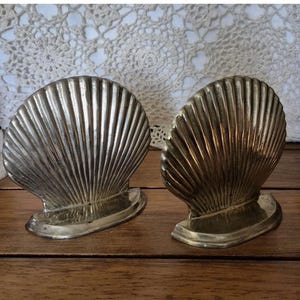 May include: A set of three ceramic mugs with a speckled, matte finish. The mugs are in shades of cream, light gray, and dark gray. Each mug has a simple, minimalist design and a rounded handle.