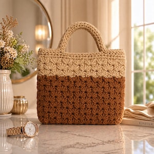 May include: A two-tone crochet tote bag in beige and brown. The bag features a starburst pattern and a sturdy handle. A gold wristwatch with a white face sits in front of the bag.