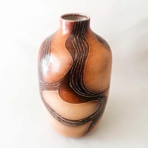 May include: A set of three ceramic mugs with a speckled, matte finish. The mugs are in shades of cream, light gray, and dark gray. Each mug has a simple, minimalist design, perfect for coffee or tea.