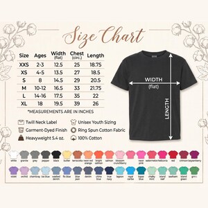 May include: A black t-shirt with a size chart and color swatches. The size chart shows measurements in inches for youth sizes, including width, chest, and length. The shirt features a twill neck label, garment-dyed finish, and is made of heavyweight 5.4 oz, 100% cotton.