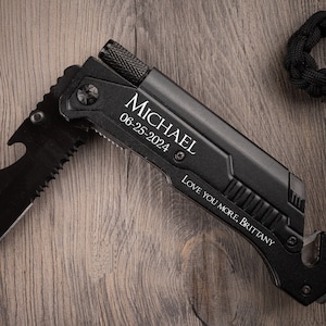 May include: Black multi-tool knife with a serrated blade, bottle opener, and a safety belt cutter. The knife is engraved with the name "Michael" and the date "06-25-2024" along with the message "Love you more, Brittany".