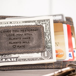 May include: A gray leather wallet with a money clip and a personalized inscription that reads "Loved you yesterday, love you still, always have, always will. Kate".