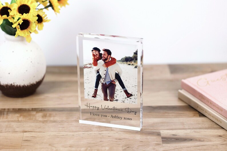 May include: A clear acrylic photo block with a picture of a couple on a beach. The text "Happy Valentine's Day I love you - Ashley xoxo" is printed on the block.