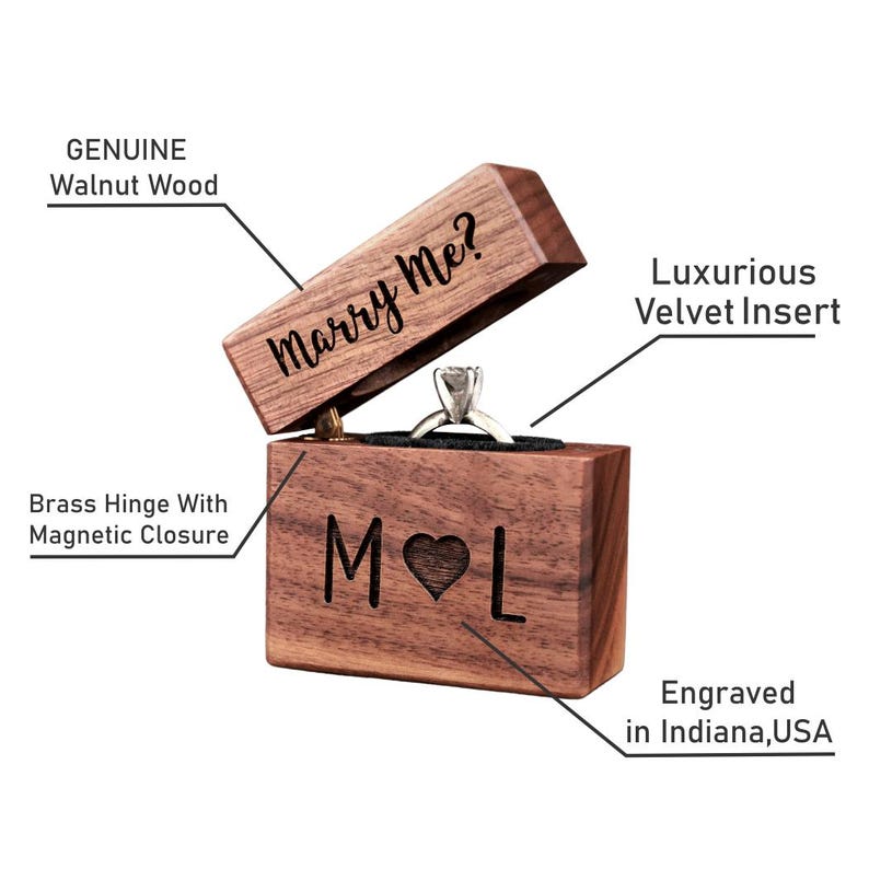 May include: A wooden ring box with a velvet insert. The lid is open and says "Marry Me?" The box is engraved with the initials "M" and "L" with a heart in between. The box is made of genuine walnut wood and has a brass hinge with a magnetic closure.