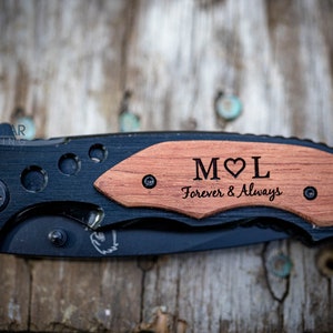 May include: A black pocket knife with a wooden handle engraved with the initials "M&hearts;L" and the text "Forever & Always".
