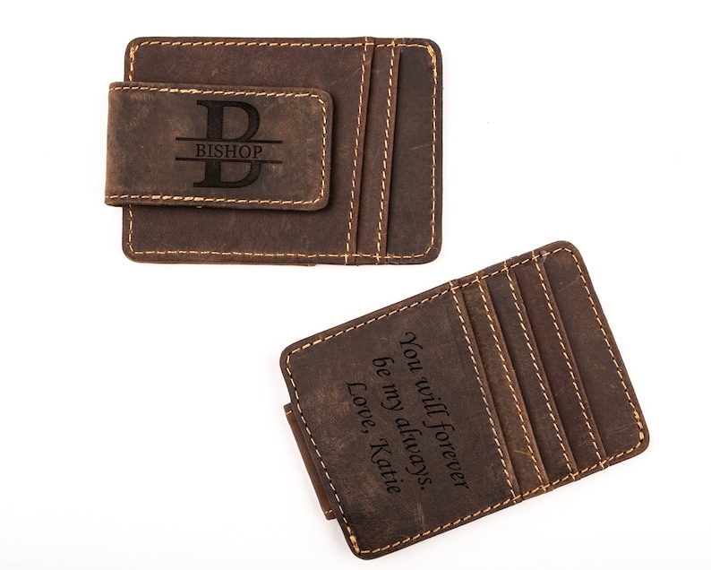 May include: Two brown leather wallets with a money clip. One wallet has the initial "B" and the name "Bishop" engraved on it. The other wallet has the text "You will forever be my always. Love, Katie" engraved on it.