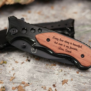 May include: A black pocket knife with a wooden handle engraved with the text "Every love story is beautiful, but ours is my favorite. Love, Sarah".