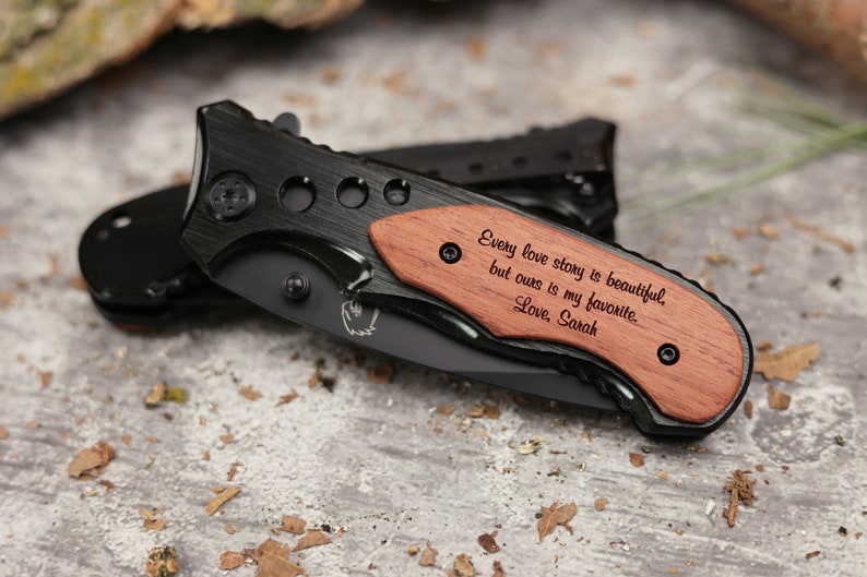 May include: A black pocket knife with a wooden handle engraved with the text "Every love story is beautiful, but ours is my favorite. Love, Sarah".