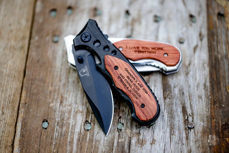 May include: Two pocket knives with wooden handles. The handle of one knife is engraved with "Grandpa's are for bear hugs and fixing things, Taylor & Jackson". The handle of the other knife is engraved with "I love you more Brittany".