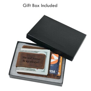 May include: A brown leather wallet with a money clip and a personalized inscription that reads "You will forever be my always!" The wallet is displayed in a black gift box.