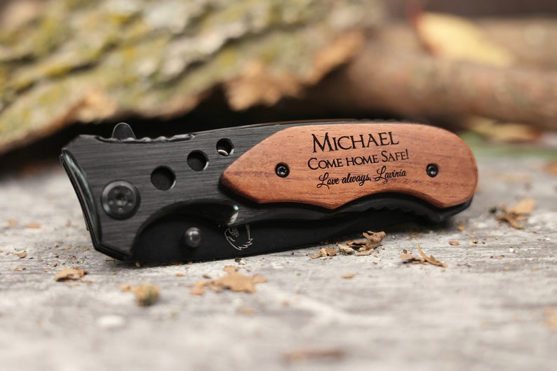 May include: A black pocket knife with a wooden handle engraved with the message "MICHAEL COME HOME SAFE! Love always, Larina."