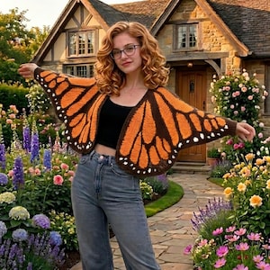 Könnte beinhalten: Eine gehäkelte Schmetterlingsflügel-Strickjacke in Orange- und Brauntönen mit weißen Punktdetails. Der offene Pullover hat ein Design mit Monarchfalterflügeln. Die Strickjacke wird über einem schwarzen Oberteil getragen und mit Jeans kombiniert. Der Hintergrund umfasst ein Steinhaus und einen Blumengarten.