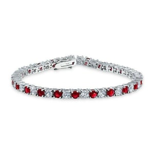 May include: A silver-toned tennis bracelet featuring alternating red and clear gemstones. The bracelet has a secure clasp and is designed with a classic, elegant style. The gemstones are round-cut and set closely together.