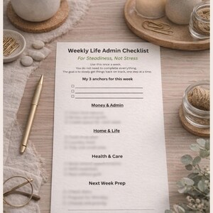 Pode incluir: Uma lista de verificação semanal de administração da vida em uma superfície de madeira, com uma xícara de café, uma vela acesa e itens decorativos. A lista de verificação inclui seções para dinheiro, casa, saúde e preparação da próxima semana. O texto diz: "Para estabilidade, não estresse".