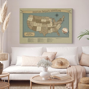 May include: A rectangular wall art print titled American Ballpark Adventures featuring a map of the United States in shades of tan and brown on a muted blue background, with a baseball graphic and a list of stadium locations.