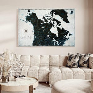 May include: A rectangular wall map of North America featuring a black landmass against a light gray background with blue text labels. The map includes a compass rose in the lower left corner and the text Adventure Awaits printed below it.