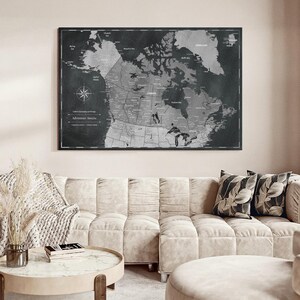 May include: A rectangular wall map of Canada featuring a dark charcoal and light gray color scheme. The map displays geographical details, including provinces, territories, and bodies of water, with the text Adventure Awaits printed in the lower left corner.